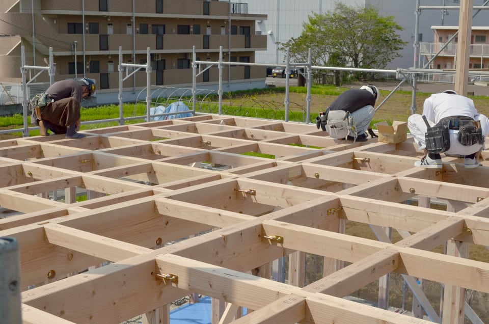 羽子板ボルトで建物天井部材同士を固定している作業員